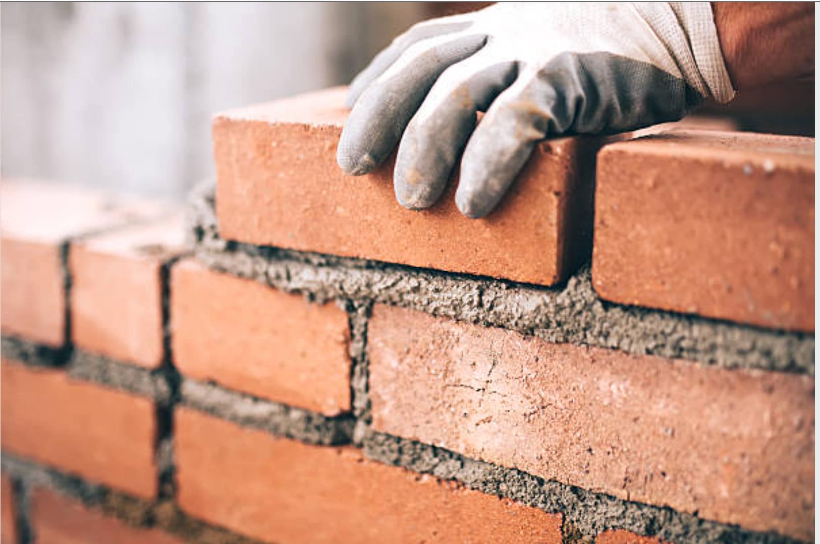 Image of hand building wall